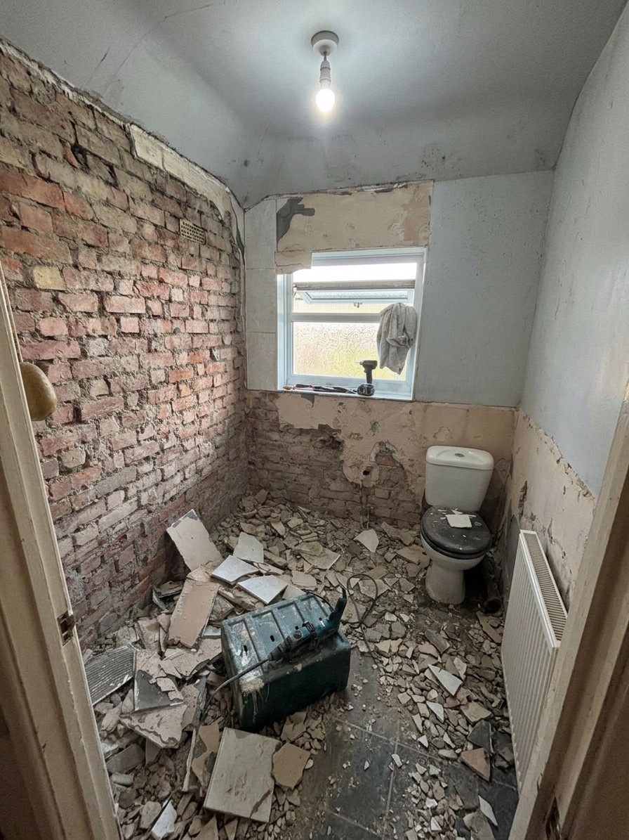 Bathroom stripped back to bare brick and floor, old tiles removed and rubble cleared ready for the new fit-out