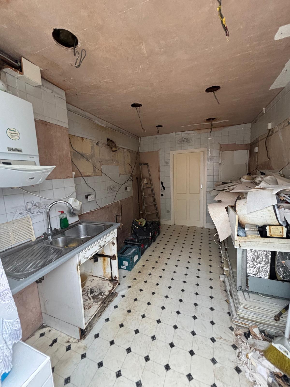 Kitchen stripped back before installation, with bare walls and old units removed